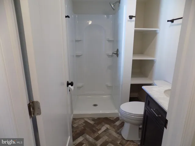 a bathroom with a granite countertop sink toilet and shower