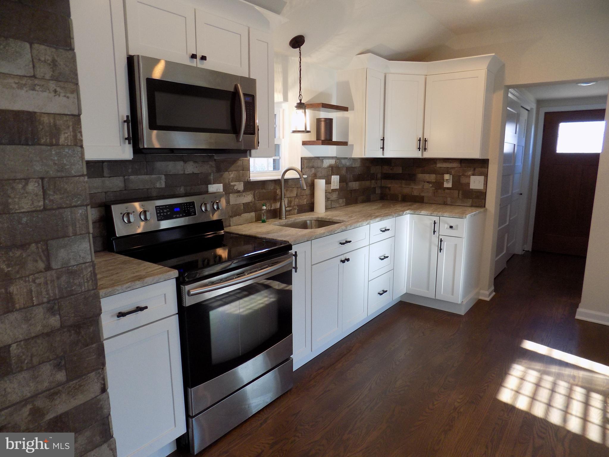 114 North Penrose Street Quakertown, PA 18951 - Photo 5 of 25 a kitchen with stainless steel appliances granite countertop a stove a sink and a microwave