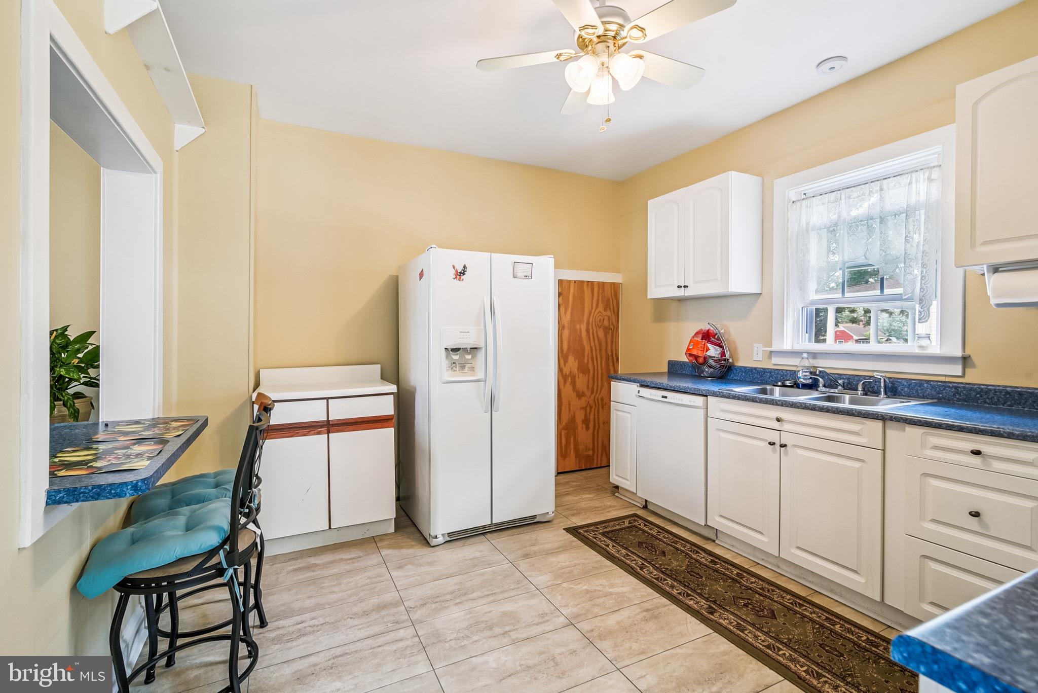 16 Columbia Avenue Crisfield, MD 21817 - Photo 16 of 36 a kitchen with refrigerator cabinets and wooden floor