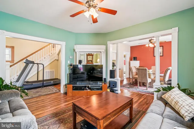 a living room with furniture a flat screen tv and a floor to ceiling window