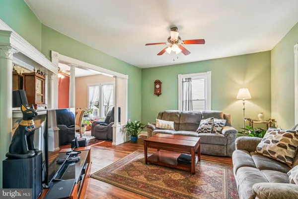 a living room with furniture a chandelier and a window