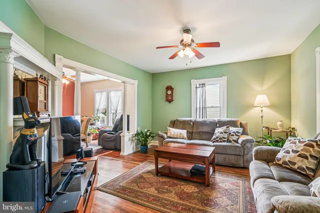 a living room with furniture a chandelier and a window
