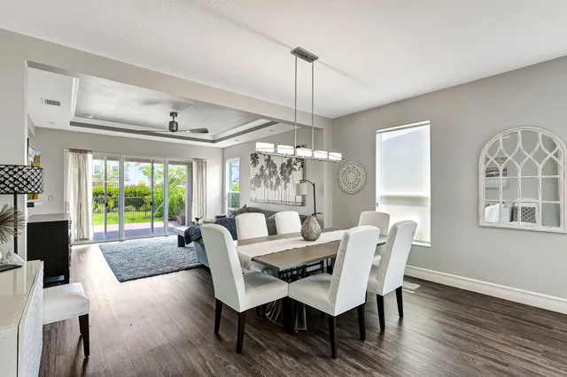 a dining room with furniture a chandelier and wooden floor