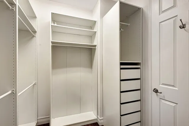 a view of walk in closet with empty racks