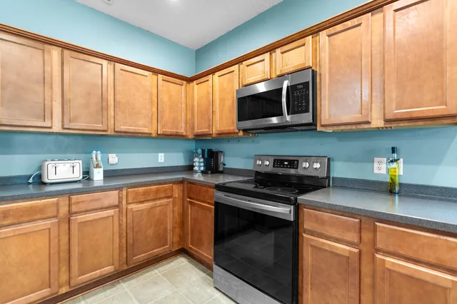 a kitchen with stainless steel appliances granite countertop a stove a sink and a microwave