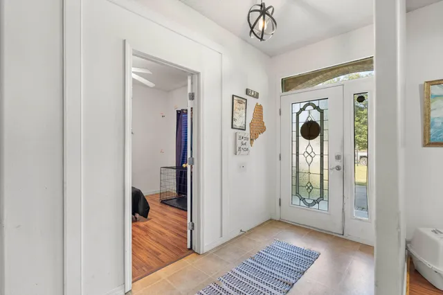 a view of a hallway with wooden floor and a bathroom
