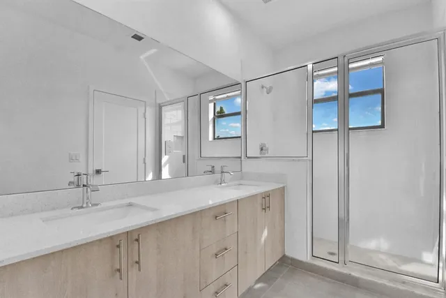 a bathroom with a double vanity sink and a mirror