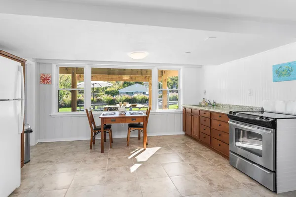a kitchen with a stove a refrigerator and a table