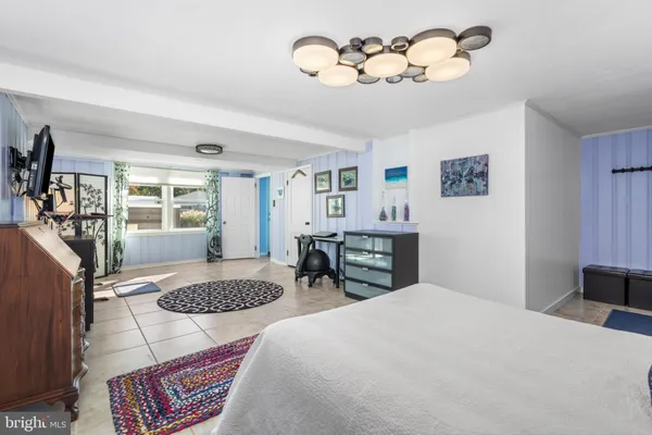 a bedroom with a large bed and a chandelier