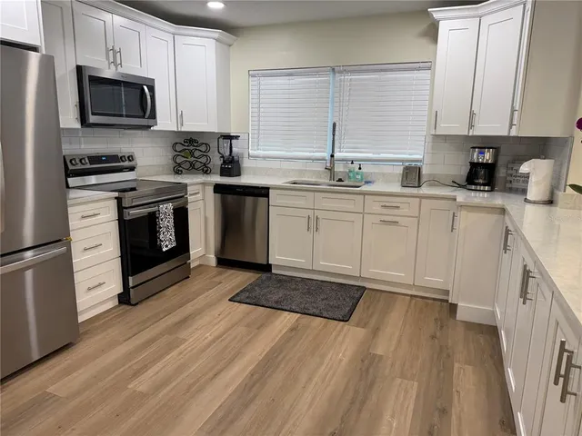 a kitchen with stainless steel appliances granite countertop a stove a sink and a microwave