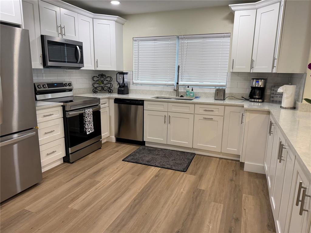 4634 McIntosh Road Sarasota, FL 34233 - Photo 6 of 20 a kitchen with stainless steel appliances granite countertop a stove a sink and a microwave