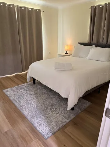 a bedroom with a bed and wooden floor