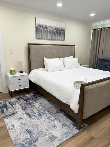 a bedroom with a bed and wooden floor