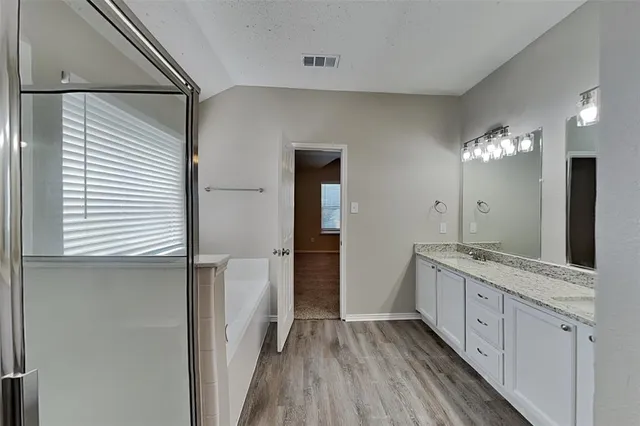 a bathroom with a double vanity sink and mirror