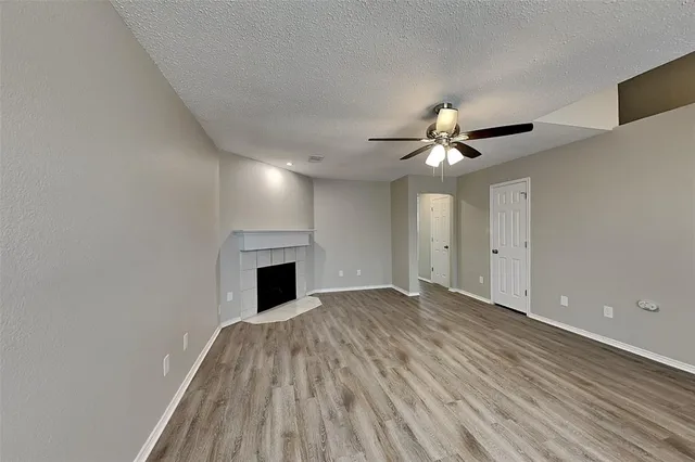 a view of an empty room with a fireplace and a window