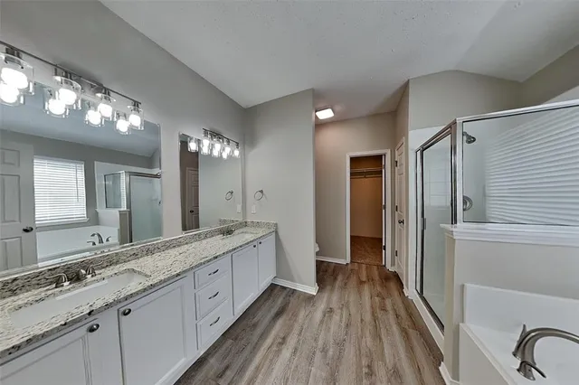 a spacious bathroom with a double vanity sink and a mirror