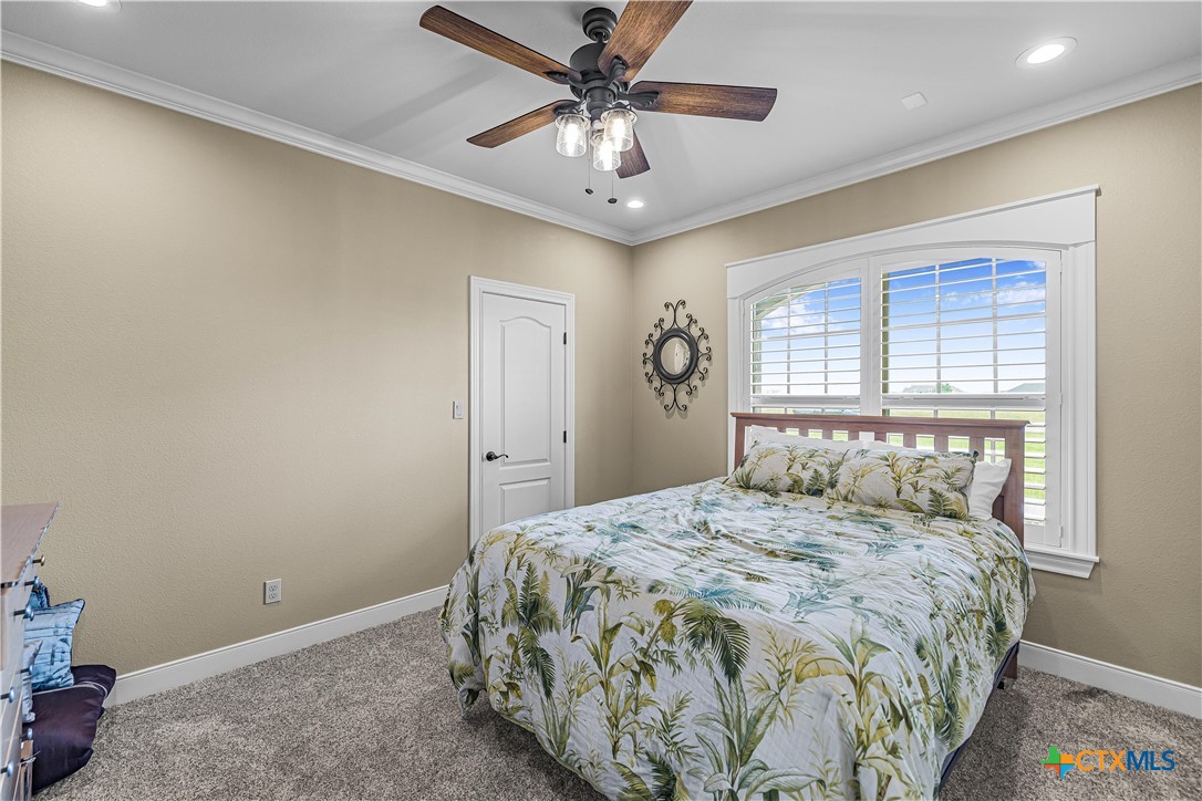 254 Sendera Loop Victoria, TX 77904 - Photo 34 of 48 a bedroom with a bed and a chandelier