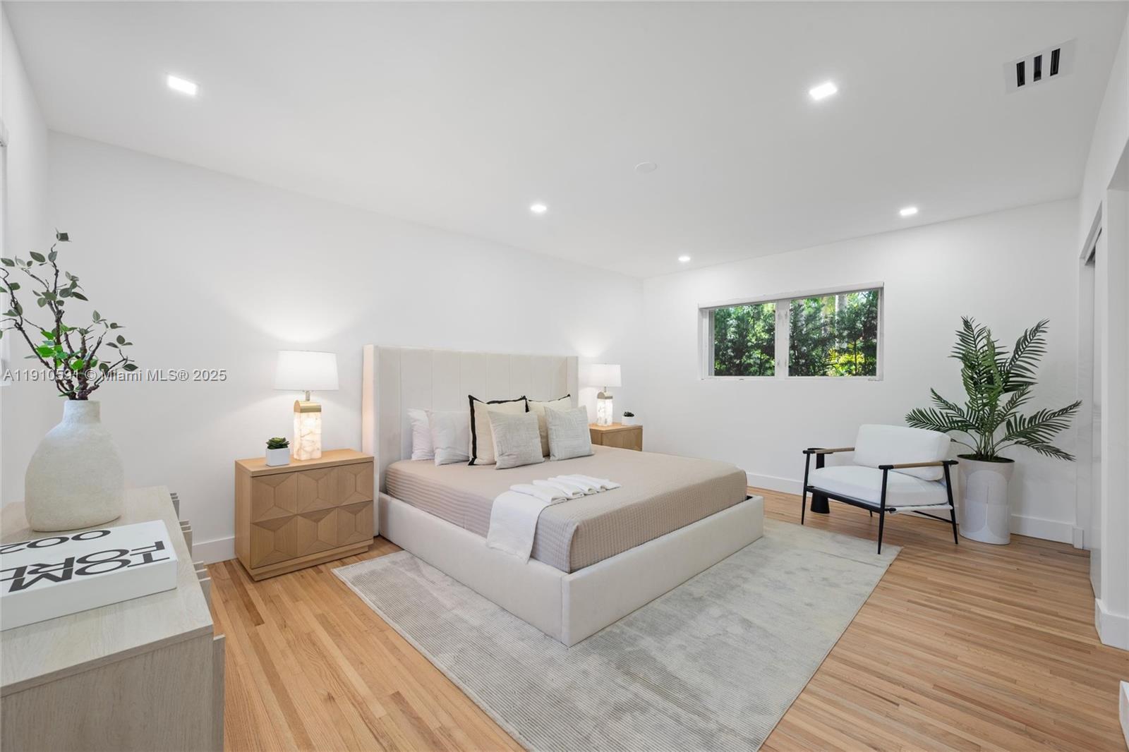 5211 Granada Boulevard Coral Gables, FL 33146 - Photo 11 of 25 a bedroom with a large bed and a potted plant