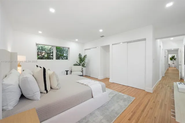 a spacious bedroom with a bed and wooden floor