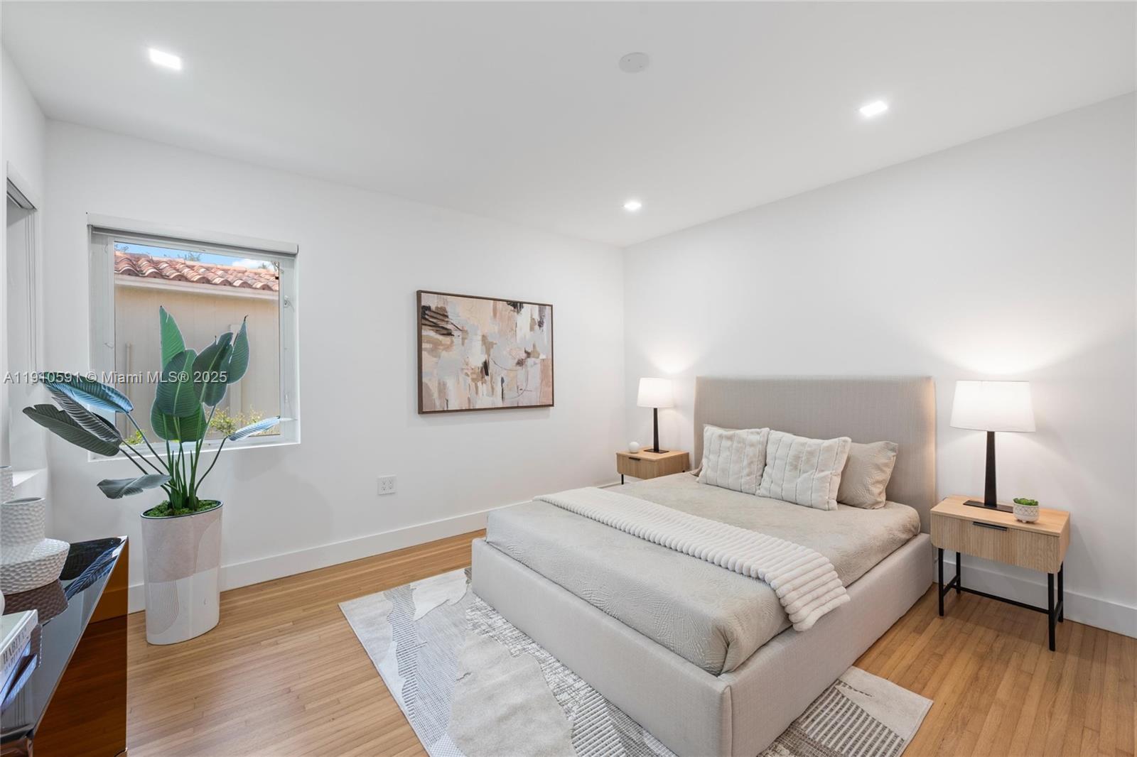 5211 Granada Boulevard Coral Gables, FL 33146 - Photo 15 of 25 a bedroom with a large bed and a potted plant