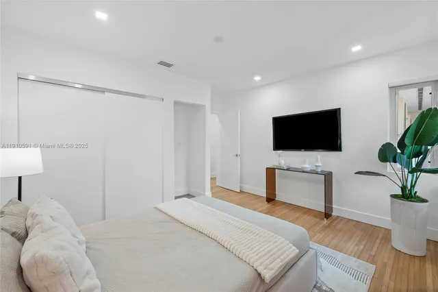 a bedroom with a bed and a flat screen tv