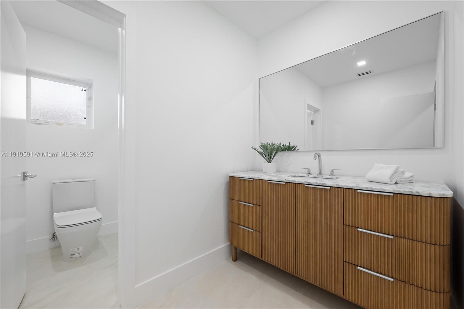 5211 Granada Boulevard Coral Gables, FL 33146 - Photo 17 of 25 a bathroom with a toilet sink and mirror