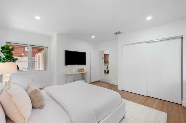 a bedroom with a bed window and a flat screen tv