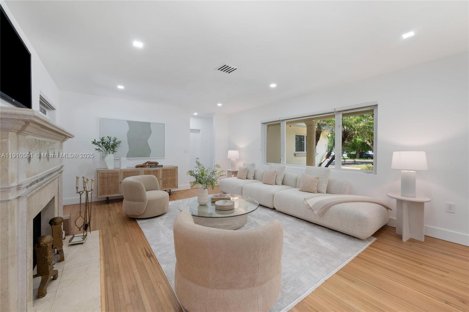 5211 Granada Boulevard Coral Gables, FL 33146 - Photo 4 of 25 a living room with fireplace furniture and a flat screen tv