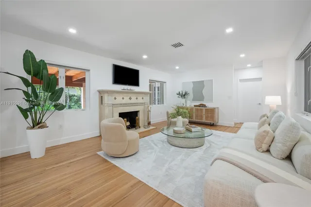 a living room with furniture a fireplace and a potted plant
