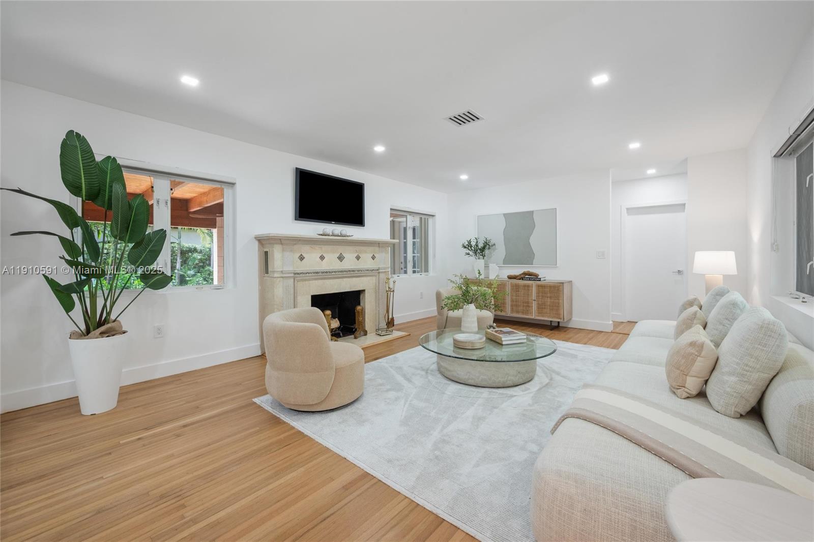 5211 Granada Boulevard Coral Gables, FL 33146 - Photo 5 of 25 a living room with furniture a fireplace and a potted plant