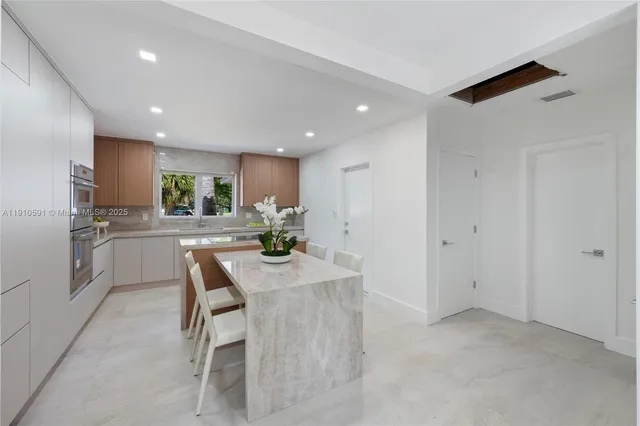 a kitchen with refrigerator and chairs