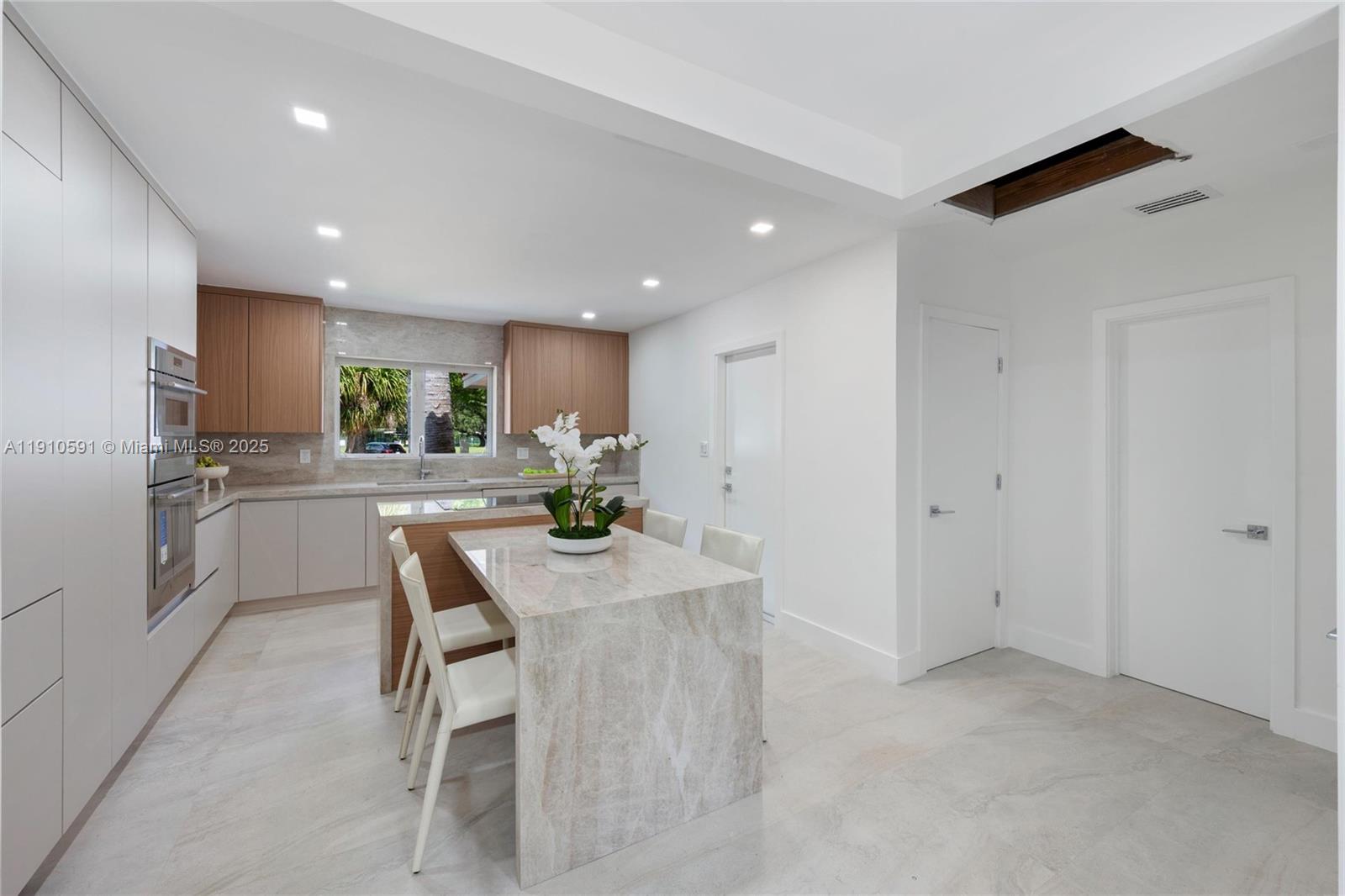 5211 Granada Boulevard Coral Gables, FL 33146 - Photo 7 of 25 a kitchen with refrigerator and chairs