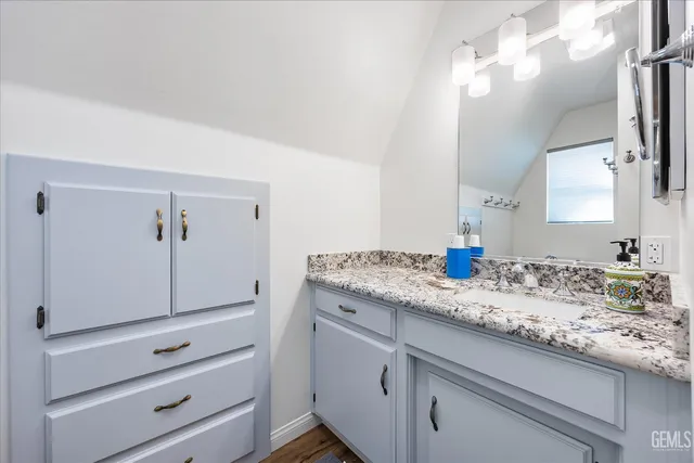 a bathroom with a granite countertop double vanity sink and mirror