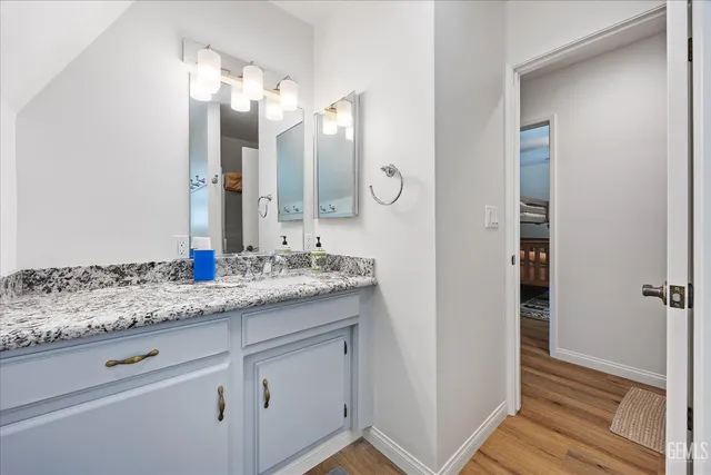 a bathroom with a granite countertop sink and a mirror