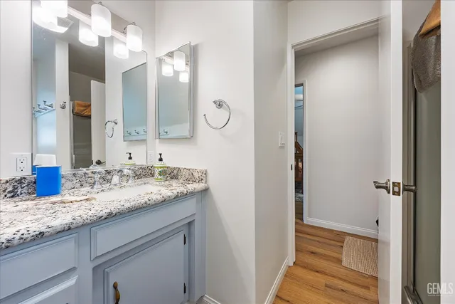a bathroom with a granite countertop sink and a mirror