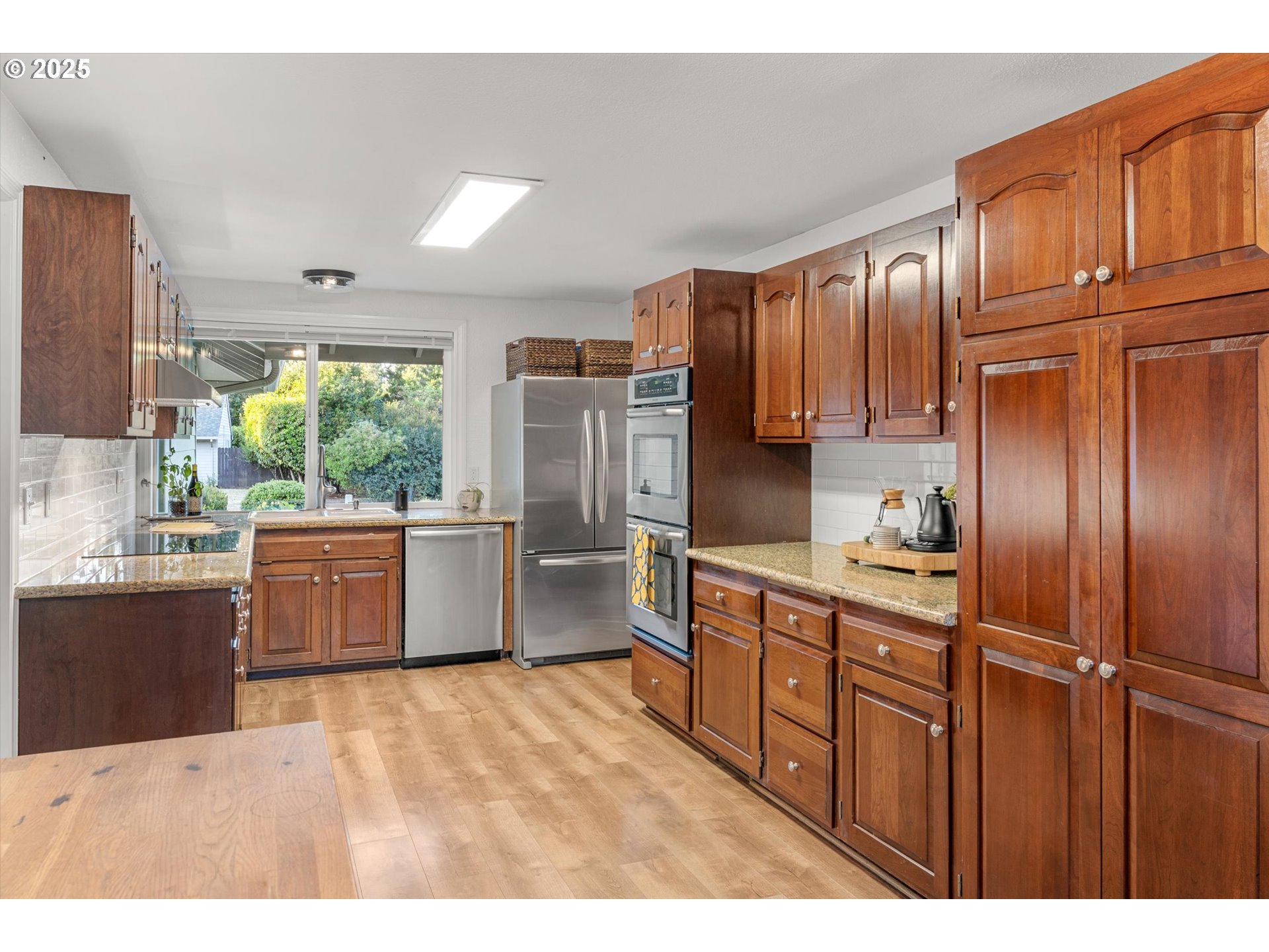 20070 Southwest Imperial Street Beaverton, OR 97003 - Photo 21 of 48 a kitchen with stainless steel appliances granite countertop a refrigerator a sink dishwasher with wooden cabinets