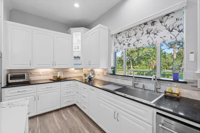 a large white kitchen with stainless steel appliances