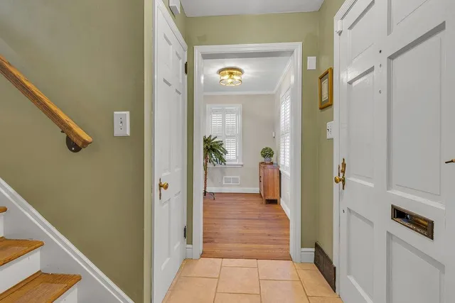 a view of a hallway with wooden floor and a living room