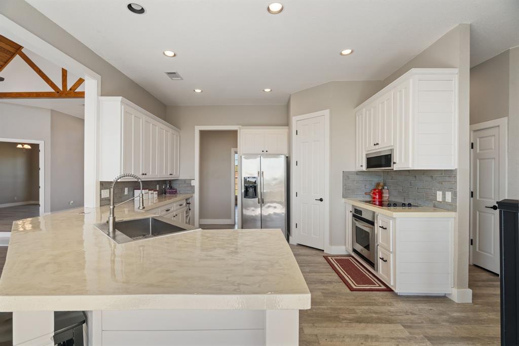 1943 Alsdorf Road Ennis, TX 75119 - Photo 13 of 39 a kitchen with stainless steel appliances granite countertop a sink a stove and a refrigerator