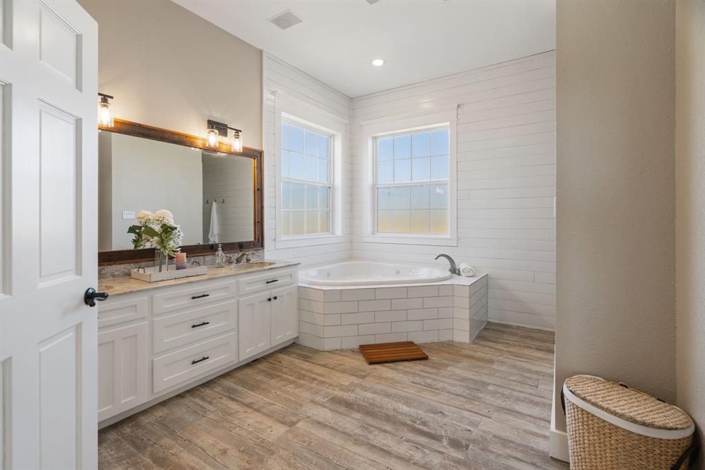 1943 Alsdorf Road Ennis, TX 75119 - Photo 19 of 39 a spacious bathroom with a granite countertop toilet a sink and a mirror