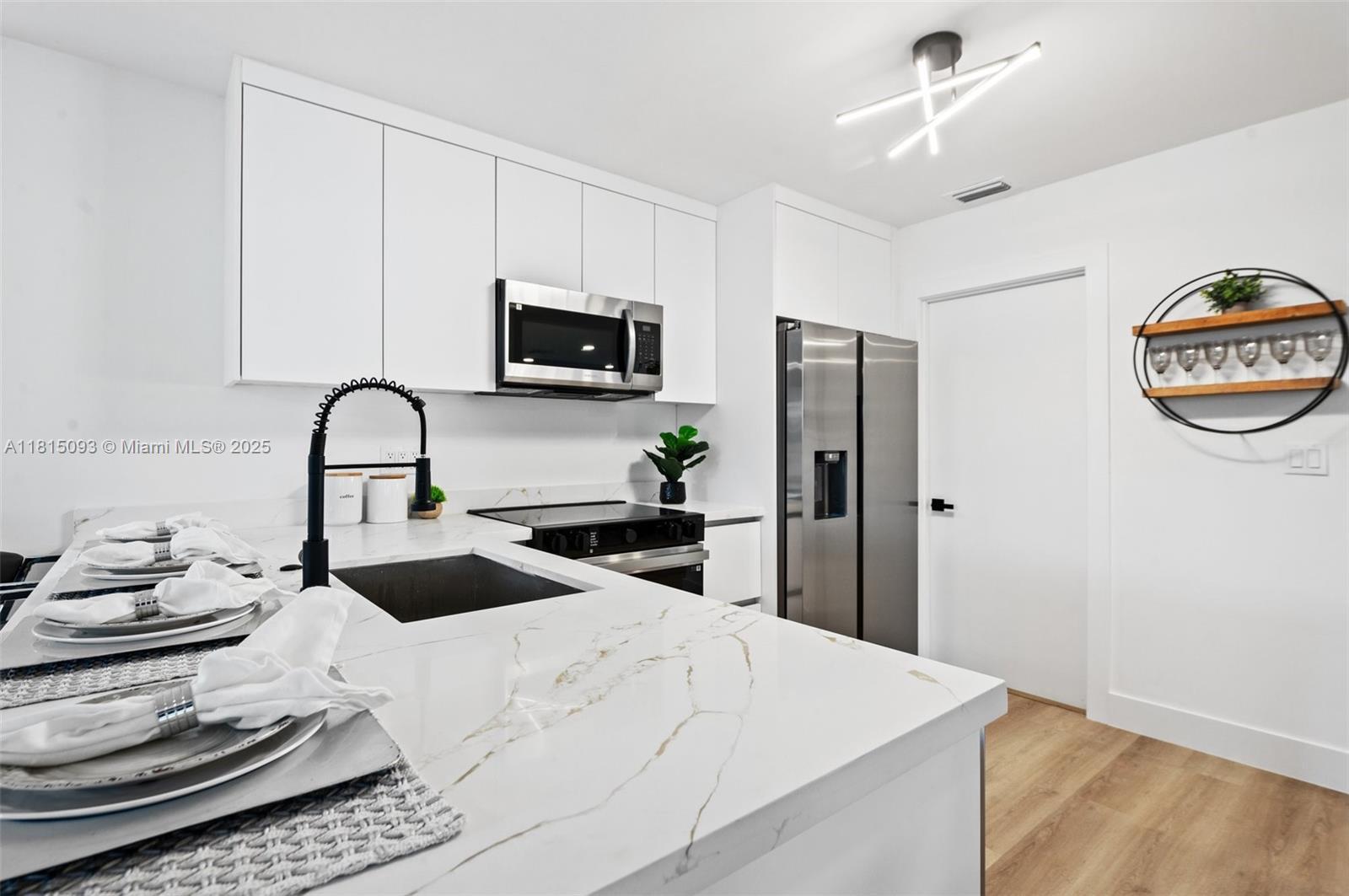 679 Southwest 17th Court Boca Raton, FL 33486 - Photo 5 of 18 a kitchen with a refrigerator and a stove top oven