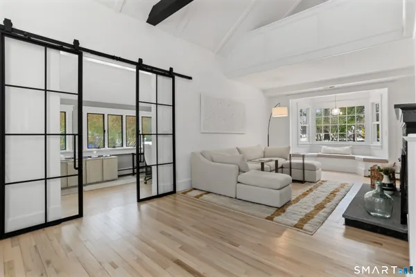 a living room with furniture a flat screen tv and a large window
