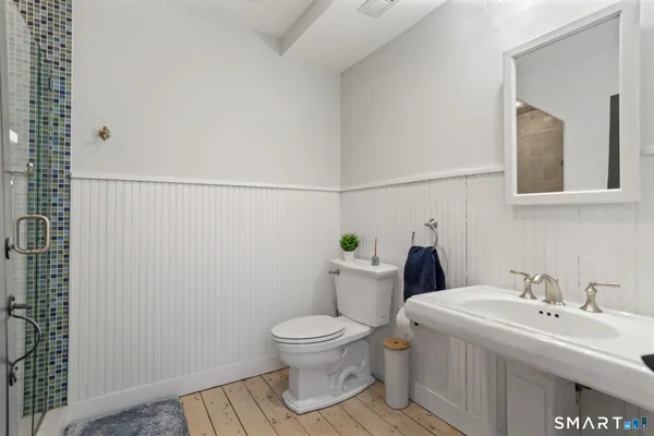 a bathroom with a toilet sink and mirror