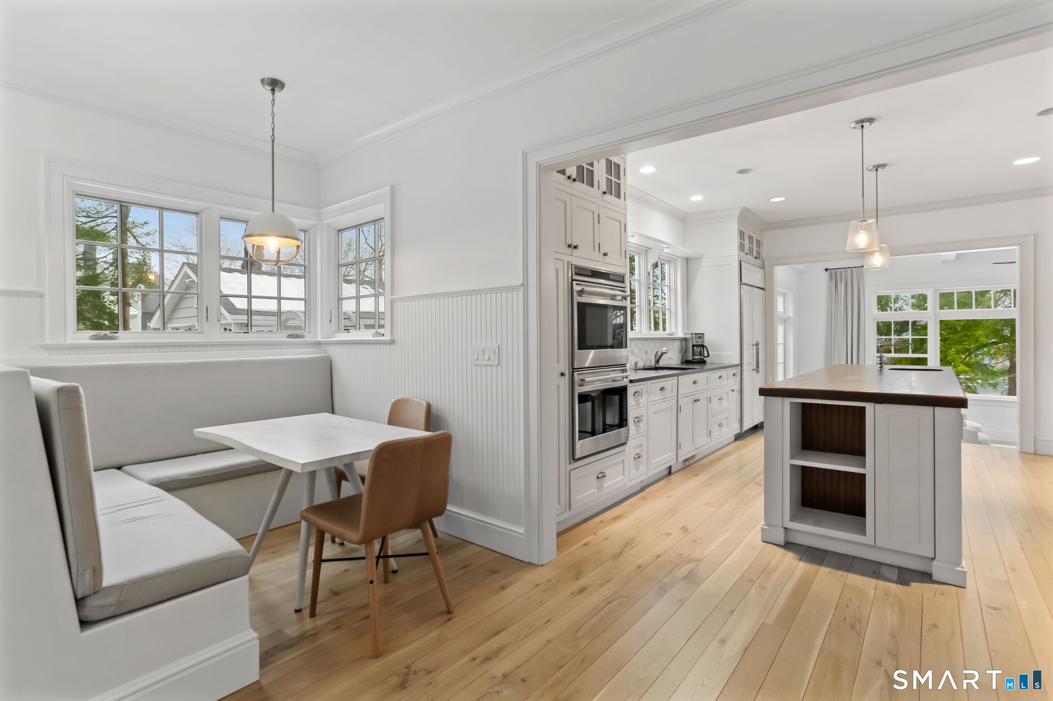 3 Riverview Road Westport, CT 06880 - Photo 7 of 29 a kitchen with stainless steel appliances granite countertop a stove top oven a sink dishwasher a dining table and chairs with wooden floor