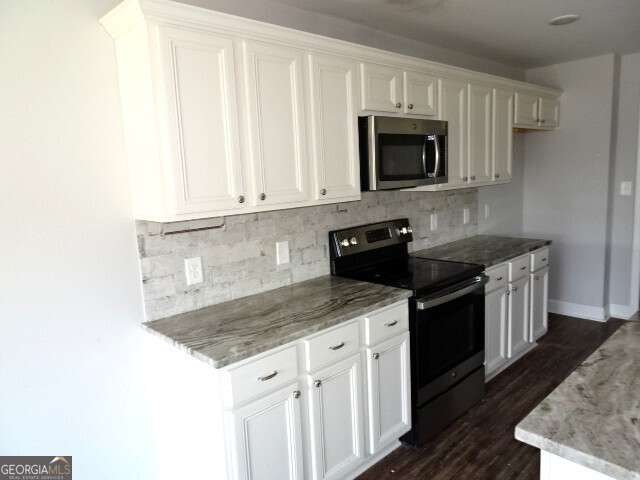 133 Worchester Circle Perry, GA 31069 - Photo 9 of 16 a kitchen with granite countertop a sink stove and microwave
