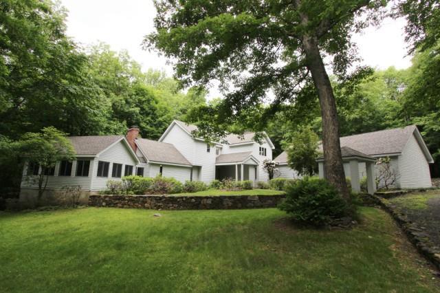 65 Hopewell Woods Road Redding, CT 06896 - Photo 1 of 1 a front view of a house with a garden and yard