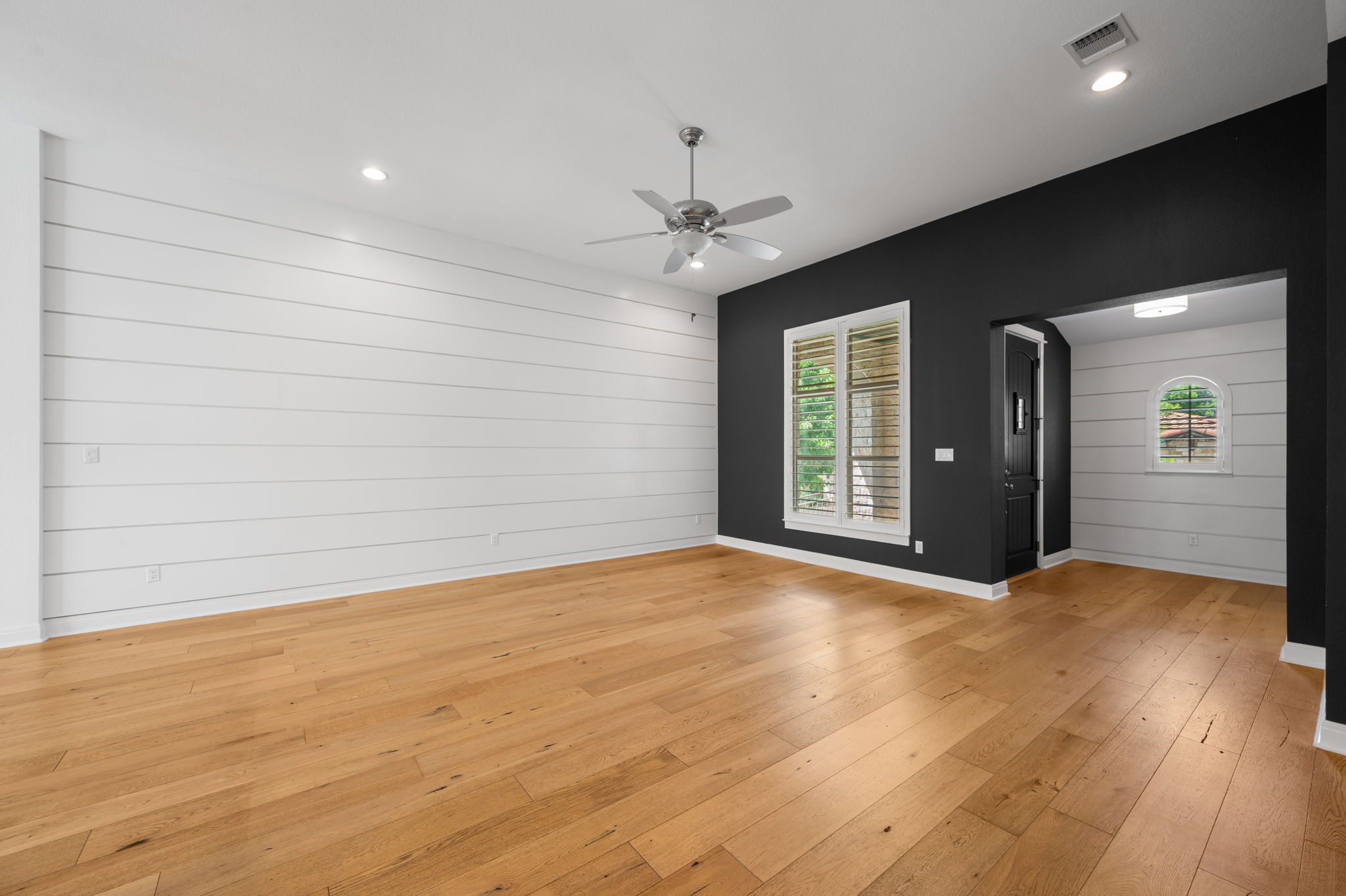 13708 Golden Wave Loop Austin, TX 78738 - Photo 13 of 34 Expansive room featuring hardwood floors, shiplap accent walls, a ceiling fan, and recessed lighting