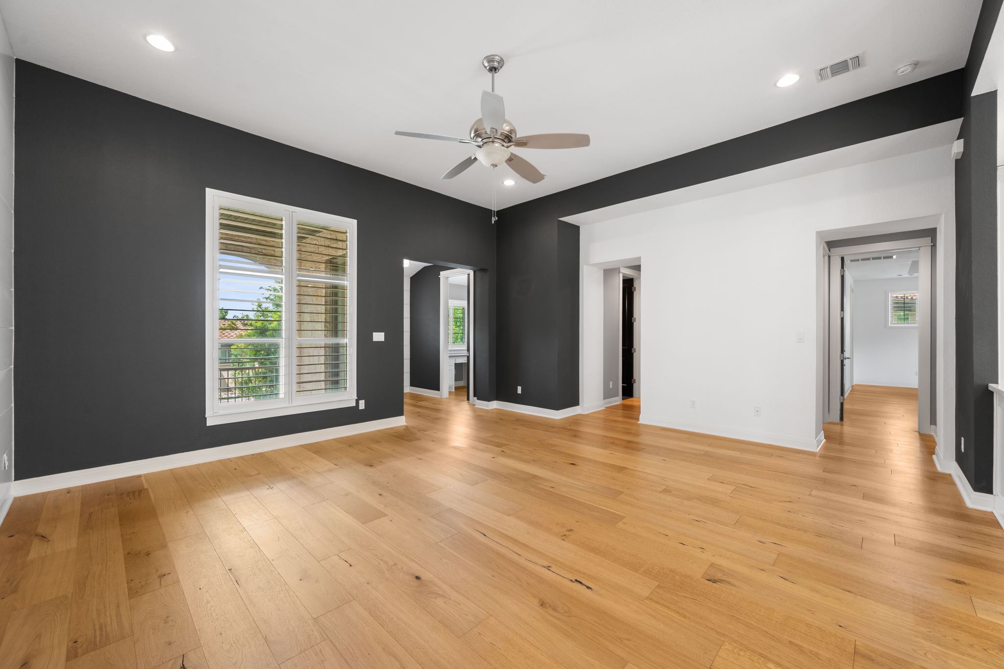 13708 Golden Wave Loop Austin, TX 78738 - Photo 14 of 34 Spacious room featuring light wood flooring, a ceiling fan, recessed lighting, and a large window with white louvered shutters