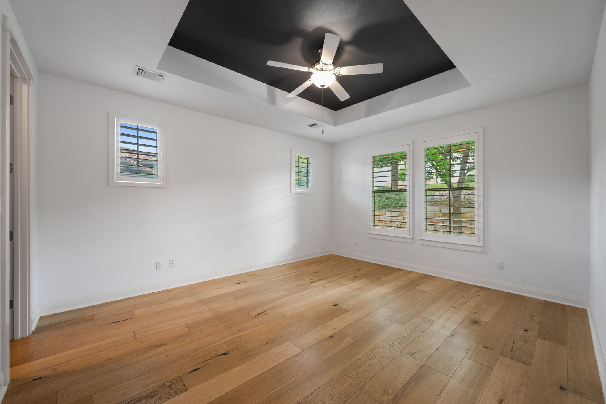 13708 Golden Wave Loop Austin, TX 78738 - Photo 17 of 34 This room features hardwood flooring, white walls, and a recessed ceiling with a dark accent
