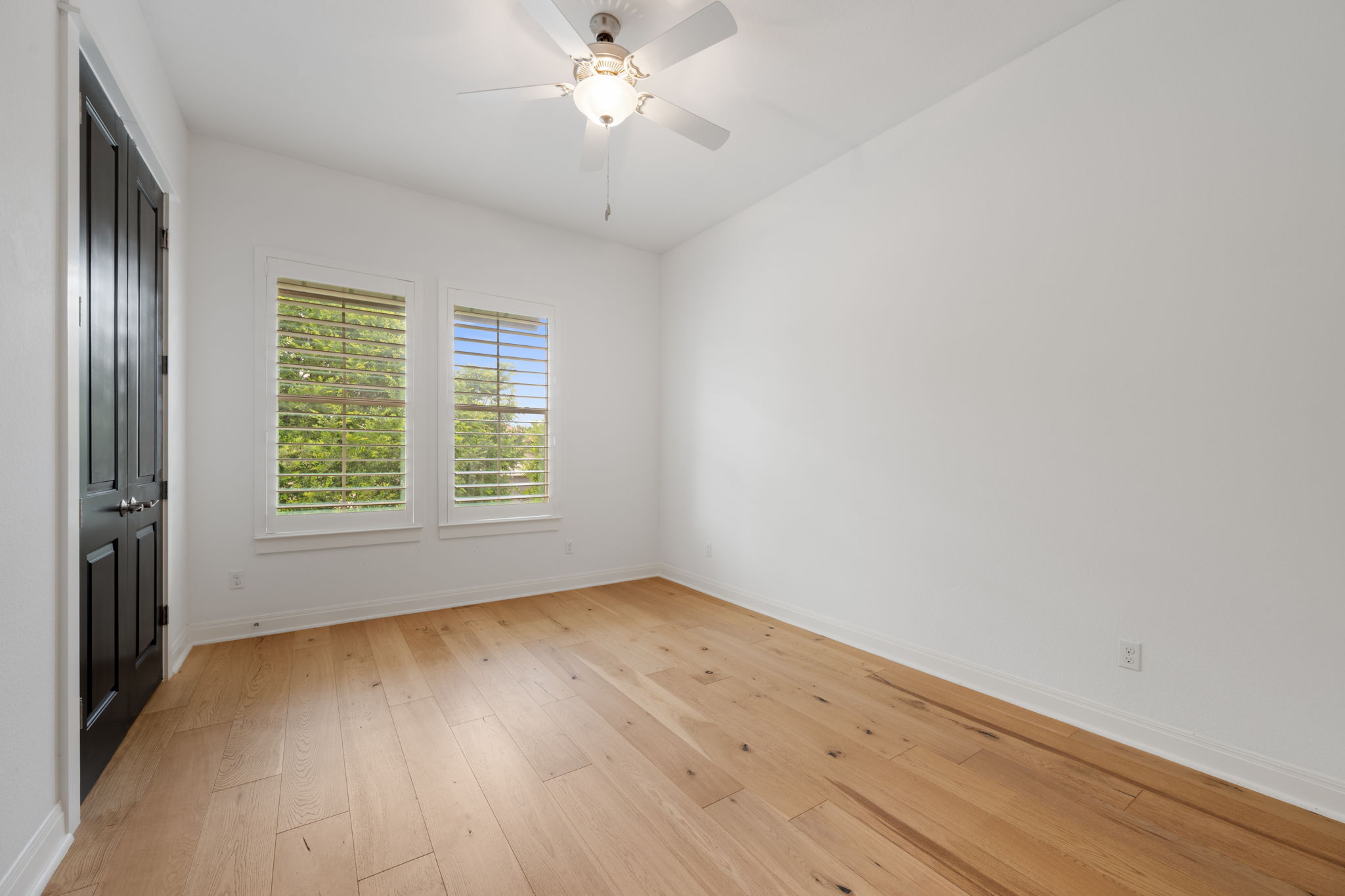 13708 Golden Wave Loop Austin, TX 78738 - Photo 23 of 34 This room features light-colored hardwood flooring, white walls, and a ceiling fan with an integrated light fixture